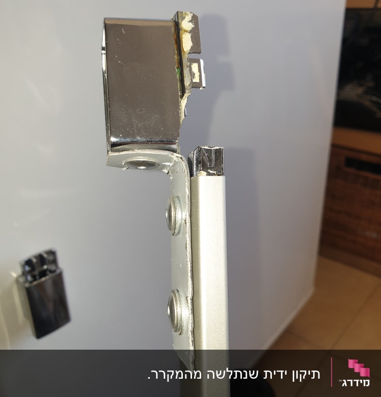 חלק מתכת עם ברגים על רקע מקרר